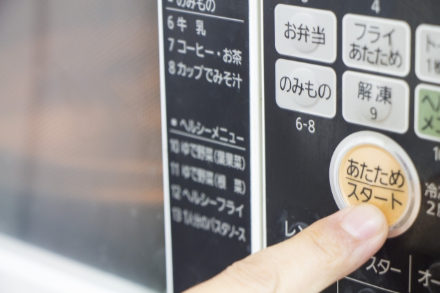 電子レンジで節約料理を作る主婦